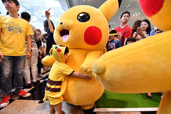 A young child greets Pikachu at Changi Airport